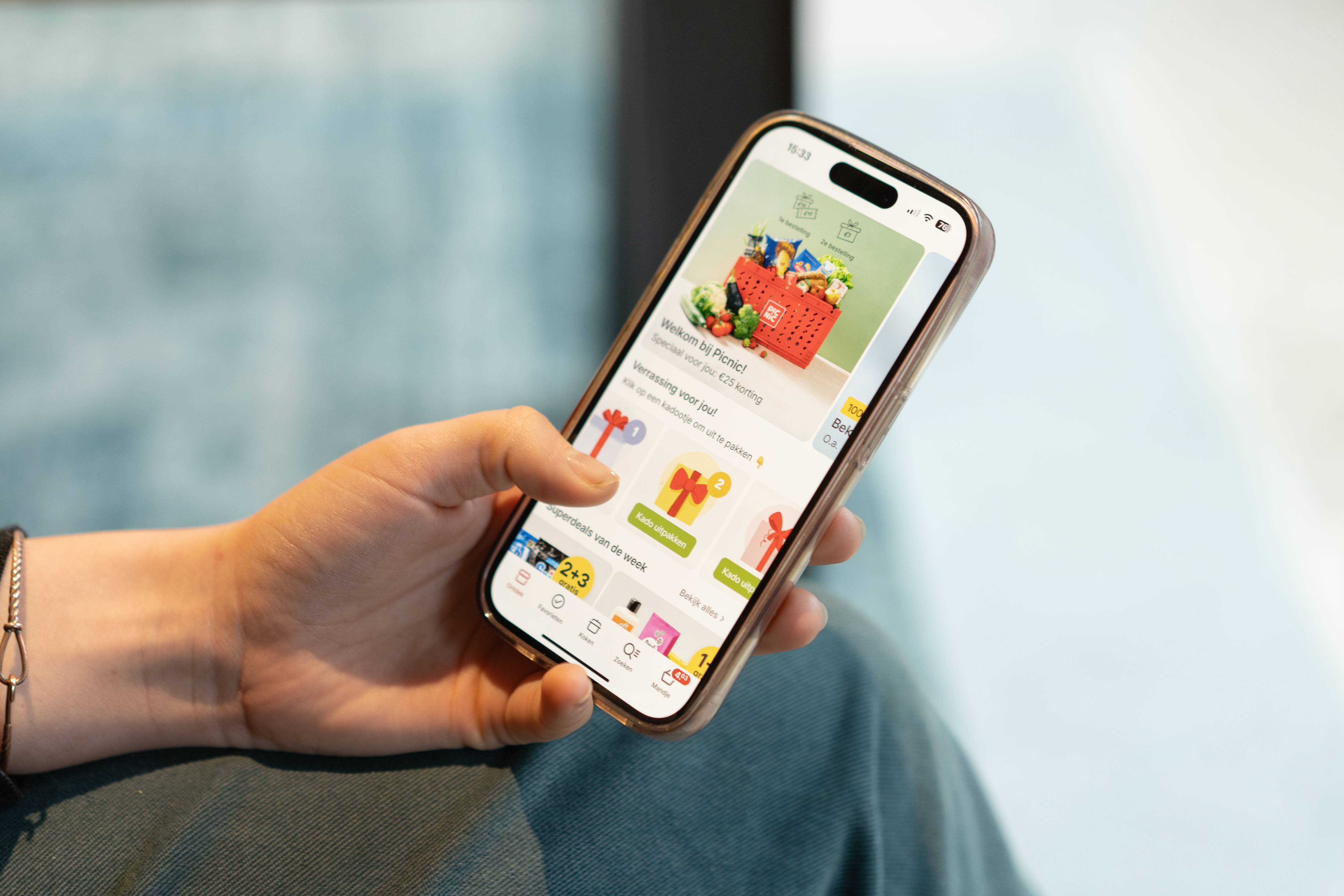 Iemand heeft een telefoon in diens hand met de Picnic app geopend.